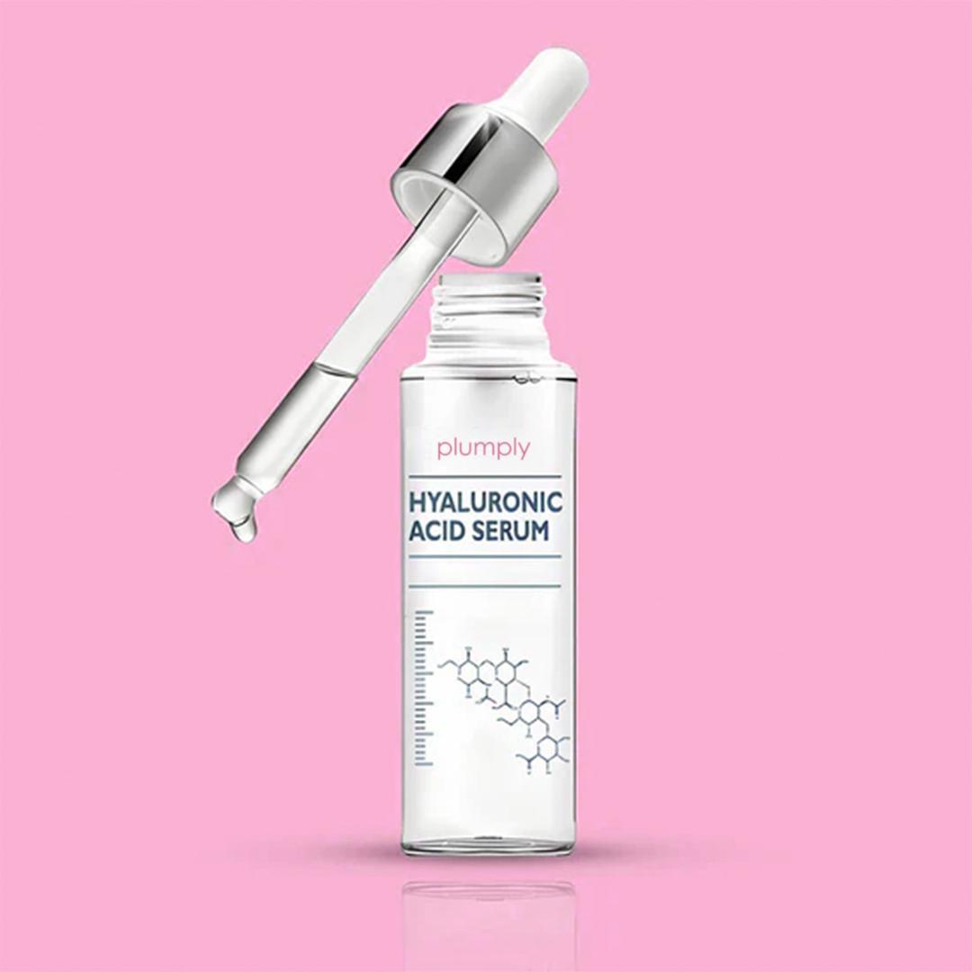 Hyaluronic acid serum bottle with dropper on a pink background